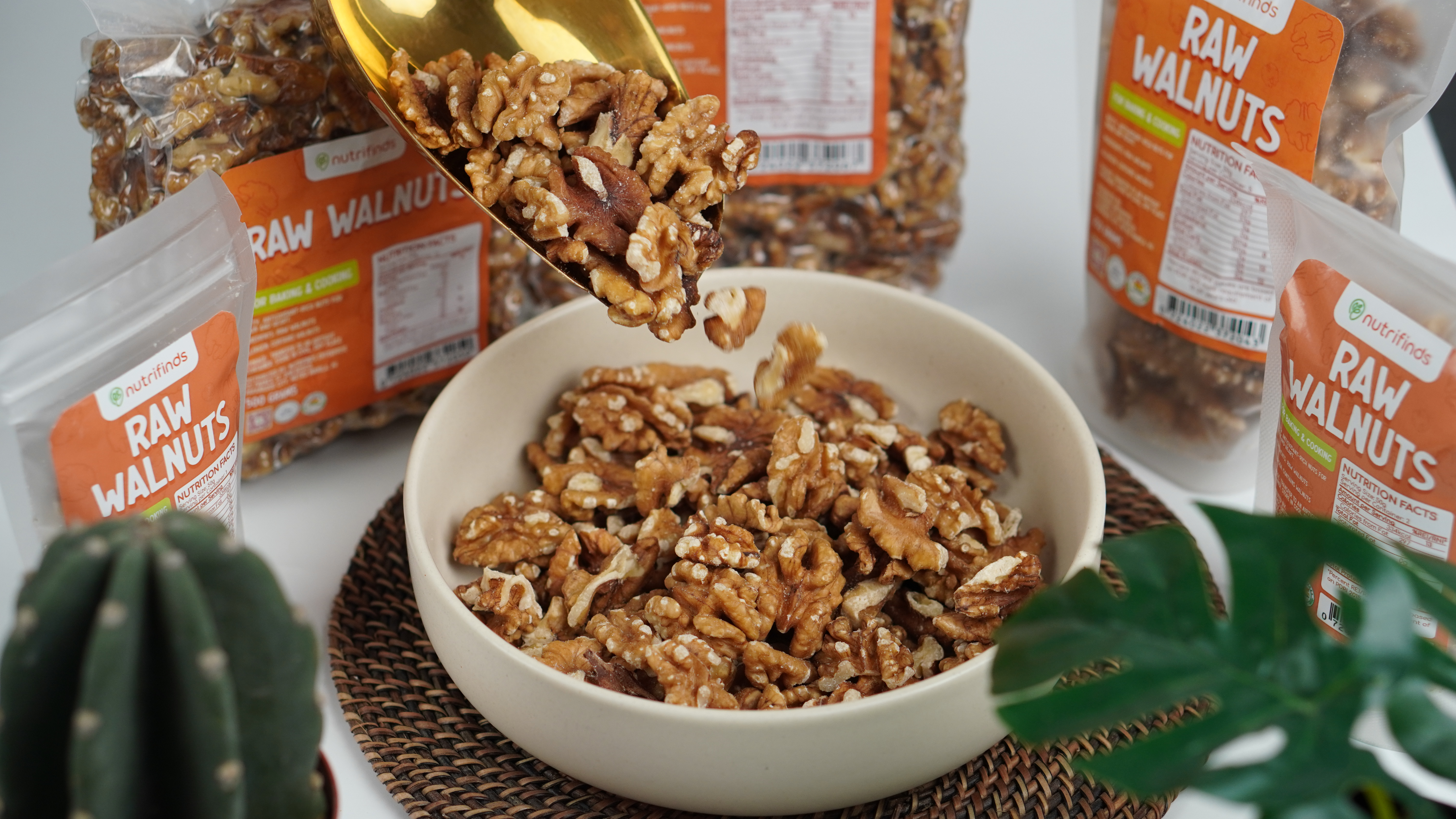 Bowl of raw walnuts beside Nutrifinds packaging